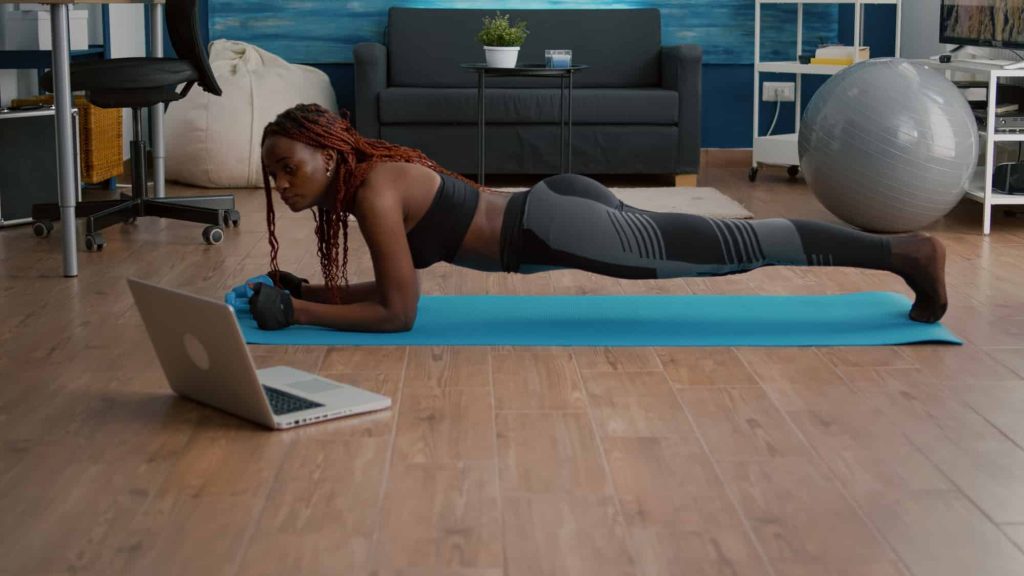 Flexible woman with black skin wearing sportswear practicing yoga sport exercises